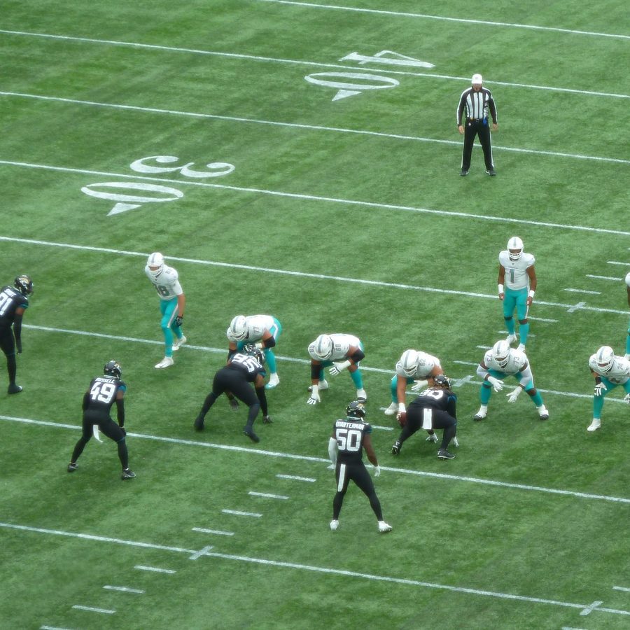 Dolphins and Jaguars players lined up at the line of scrimmage during an NFL game.