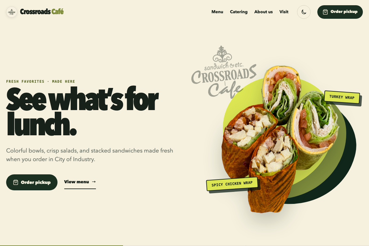 Crossroads Café homepage hero showing fresh lunch wraps beside a pickup ordering button and menu and catering navigation.